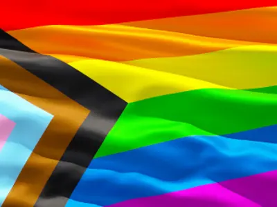 Close up of rainbow Pride flag rippling as if waving in wind.